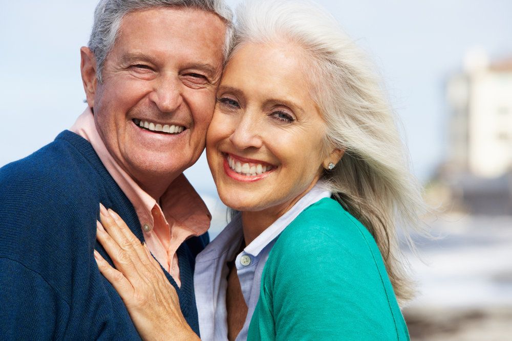 Senior couple smiling and pressing their cheeks together