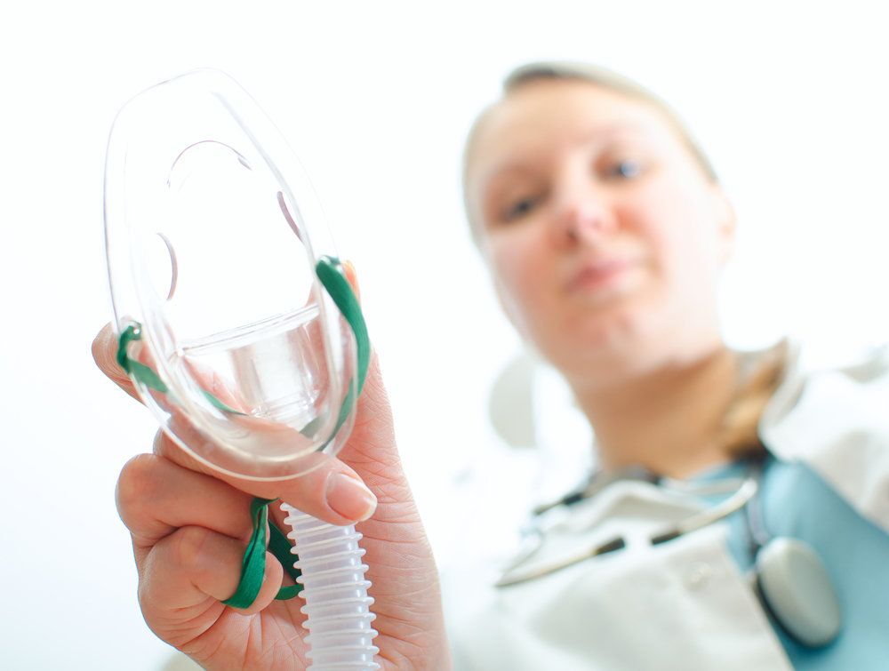 Woman administering nitrous oxide mask to viewer